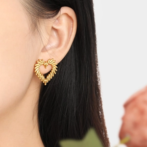 Chic hollow heart stud earrings in polished gold-plated finish on model's ear