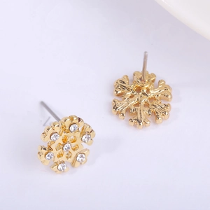 Macro shot of snowflake stud earrings with gold plating and white rhinestones