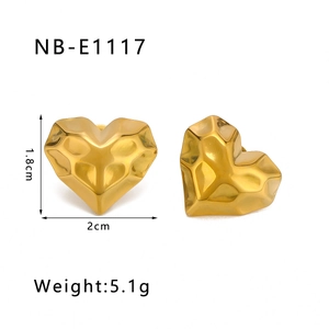 Macro shot of gold heart stud earring showing textured 3D geometric facets and dimensions