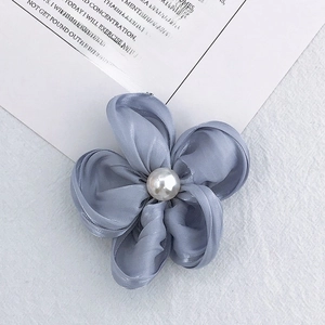 Detailed view of dusty blue silk flower with pearl center for DIY hair accessories