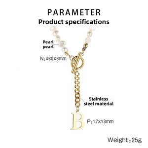 Detail of pearl necklace with gold letter B pendant and stainless steel OT clasp