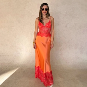 Gros plan détaillé de la robe longue en satin orange avec empiècements en dentelle rouge