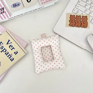 Close-up of pink polka dot plush card holder for photos on a cute Korean style desk