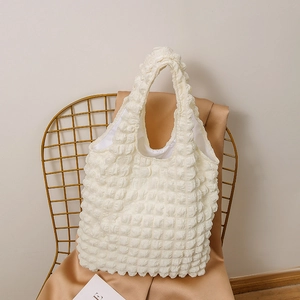 Detail showing white waffle textured puff tote bag with soft popcorn fabric surface