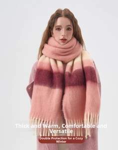 Close-up of thick knitted winter scarf featuring pink and beige stripes with long tassels