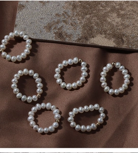 Detailed view of elastic 14K gold filled rings with natural freshwater pearls