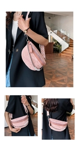 Detail view of pink crescent sling bag featuring elegant pearl chain and woven shoulder strap