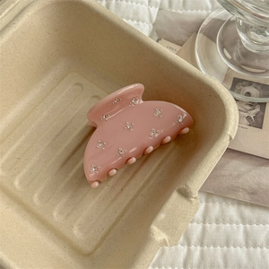 Detail of pink acrylic hair claw clip with rhinestones in a minimalist ins-style setting