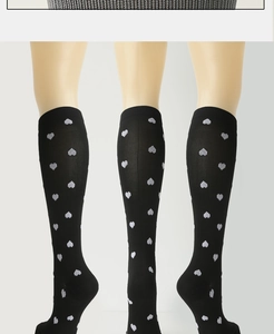 Detailed view of black compression socks with white heart patterns shown from three angles