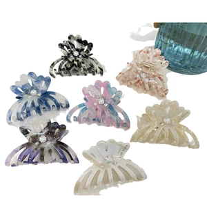 Elegant floral acetate hair claws set with rhinestones and marble patterns on white background