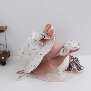 Detailed stack of floral and solid kids sun hats with large bows and chin straps