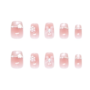 Handmade press-on nails with pink gradient, 3D pearls, and glittery bow tie accents