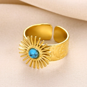 Detailed macro view of gold sun totem ring featuring a round turquoise stone and textured band