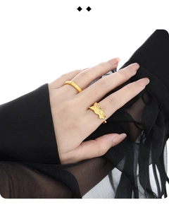 Close-up of minimalist gold S925 sterling silver rings on hand with black tulle background