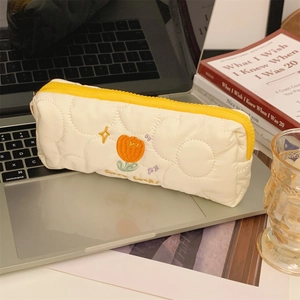 Quilted white pencil case with orange tulip embroidery and yellow zipper detail
