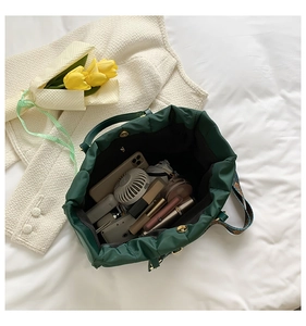 Macro shot of dark green drawstring tote bag interior showing large storage capacity