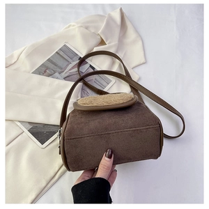 Detail of dark brown faux suede bag with beige faux fur trim and sleek shoulder strap