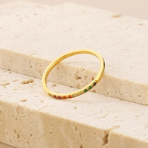 Elegant gold titanium steel ring with colorful zircon inlay on natural stone background