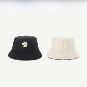 Detail of black and beige cotton bucket hats featuring delicate daisy flower embroidery