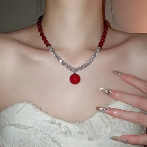 Elegant beaded necklace with red zircon stones, pearls, and a large central red pendant
