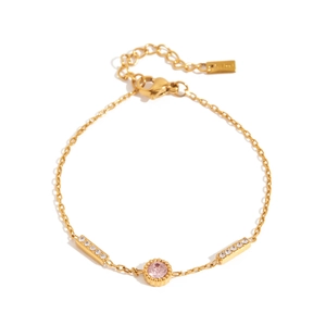 Detail of gold chain bracelet featuring a round pink gemstone and cubic zirconia accents