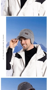 Details der grauen Herren-Strickmütze mit Ohrenschützern und Leder-Logo im Winter-Design