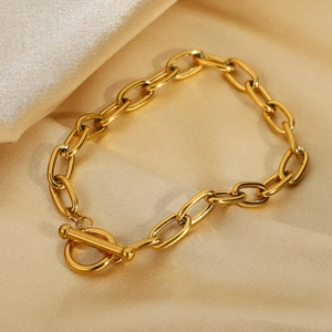 Classic gold paperclip chain bracelet with OT toggle clasp on golden silk fabric