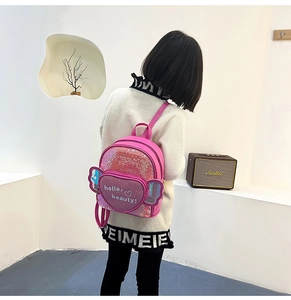 Pink sequin kids backpack with purple heart detail and shiny wings worn by a child
