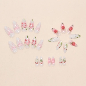 Close-up of almond nails with hand-painted pink flowers, bows, and strawberries