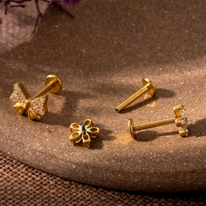 Macro shot of G23 titanium labret studs with butterfly and flower zircon inlay