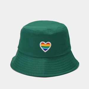 Detail of rainbow heart embroidery on a dark green cotton bucket hat with a wide brim