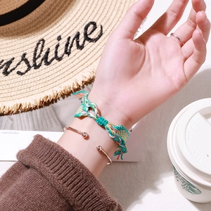Square quartz watch with bohemian woven bracelet and rose gold cuff on female wrist