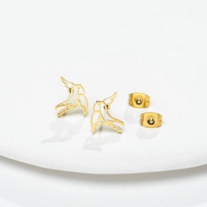 Exquisite gold hollow bird stud earrings shown on white ceramic plate background