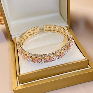 Gros plan d'un bracelet doré avec oxydes de zirconium dans son coffret à bijoux