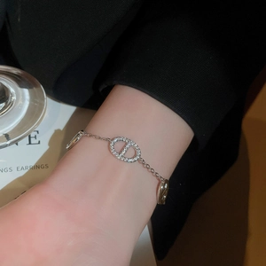 Close-up of silver-plated bracelet with zircon-encrusted anchor link on a woman's wrist