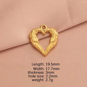 Detail view of heart wing pendant with dimensions 19.5x17.7mm on soft pink fabric