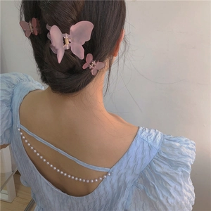 Matte butterfly hair clips in pink and purple colors worn in a stylish bun updo