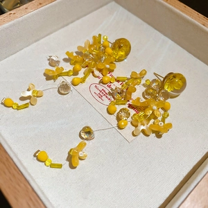 Detailed macro view of yellow resin flower petals and beaded tassels on earring