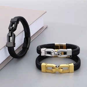 Detailed view of men's braided leather bracelets with black, gold and silver metal clasps