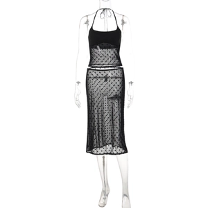 Détail du tissu en maille à pois noirs et haut licou sur une robe midi moulante