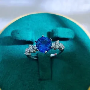 Detail of round dark blue sapphire ring with six-prong setting in green velvet box