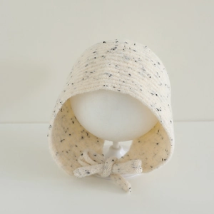 Détail du bonnet en maille crème avec fils chinés et texture tissée pour enfants