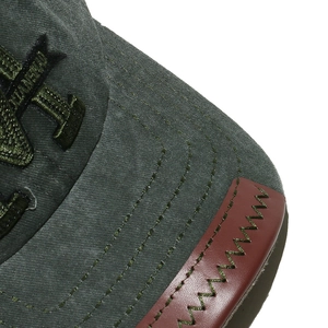 Macro detail of washed canvas baseball cap with red leather patch and Z-stitch
