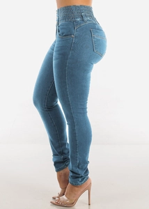 Detail of high waisted skinny jeans featuring three-button closure and lifting fit
