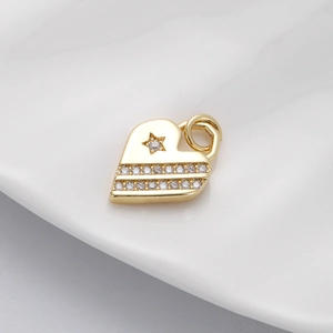 Detailed view of a golden heart pendant with star pattern and shimmering cubic zirconia