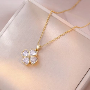 Elegant gold necklace with purple heart-shaped zircon clover pendant on jewelry box