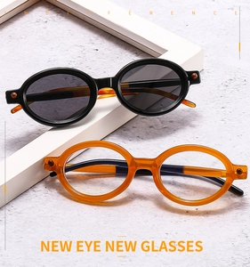 Detail of oval sunglasses in black and amber frames with stylish metal accents