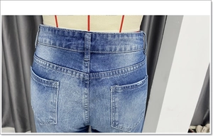 Detailweergave van blauwe jeans met hoge taille en focus op de achterzakken