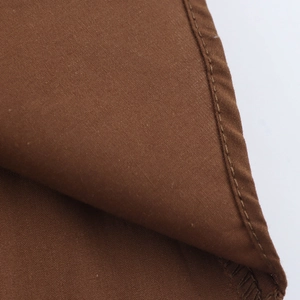 Macro shot of brown cotton poplin fabric texture and professional stitching details