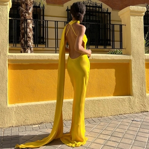 Elegant yellow one-shoulder dress back view featuring long floating ribbons and backless cut